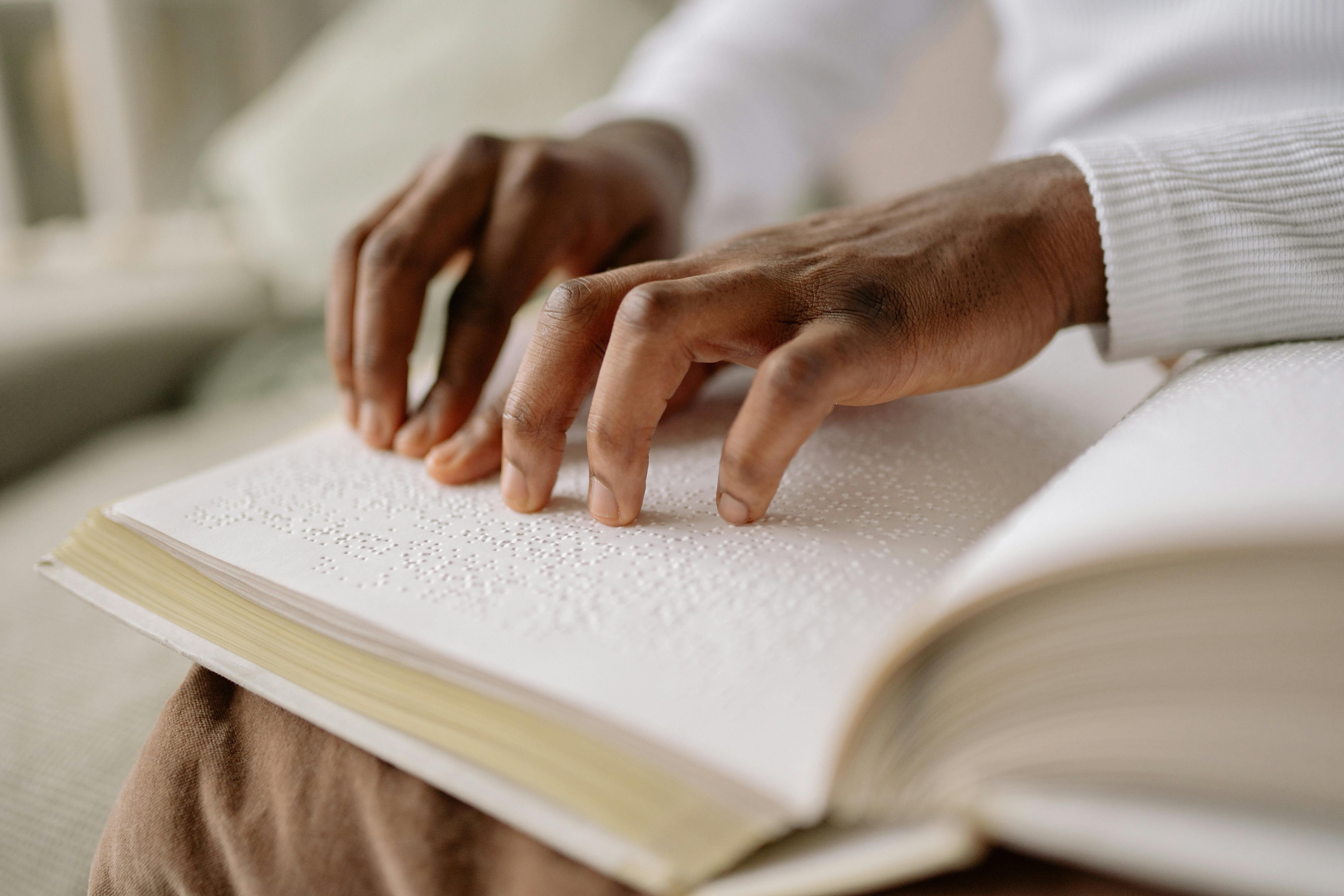 person in white long sleeve shirt holding a white book