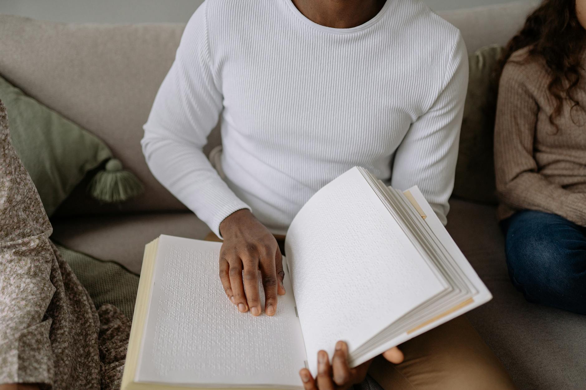 Person in White Long Sleeve Shirt Holding a Book