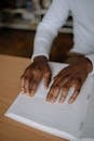 Close up of a Person Reading a Braille Book