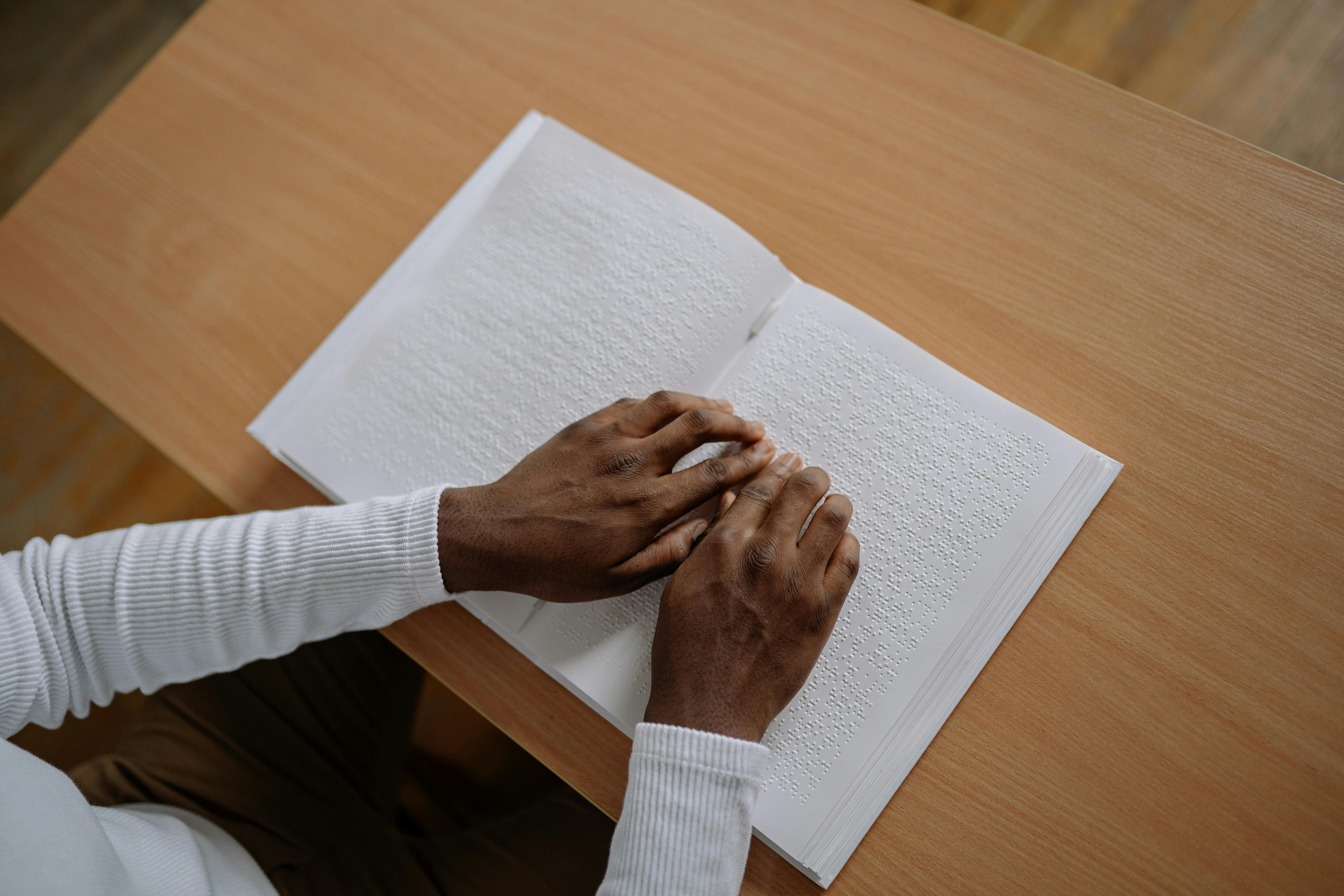 close up of a person reading a braille book