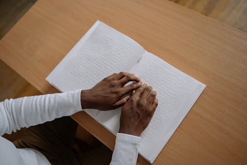 Free Close up of a Person Reading a Braille Book Stock Photo