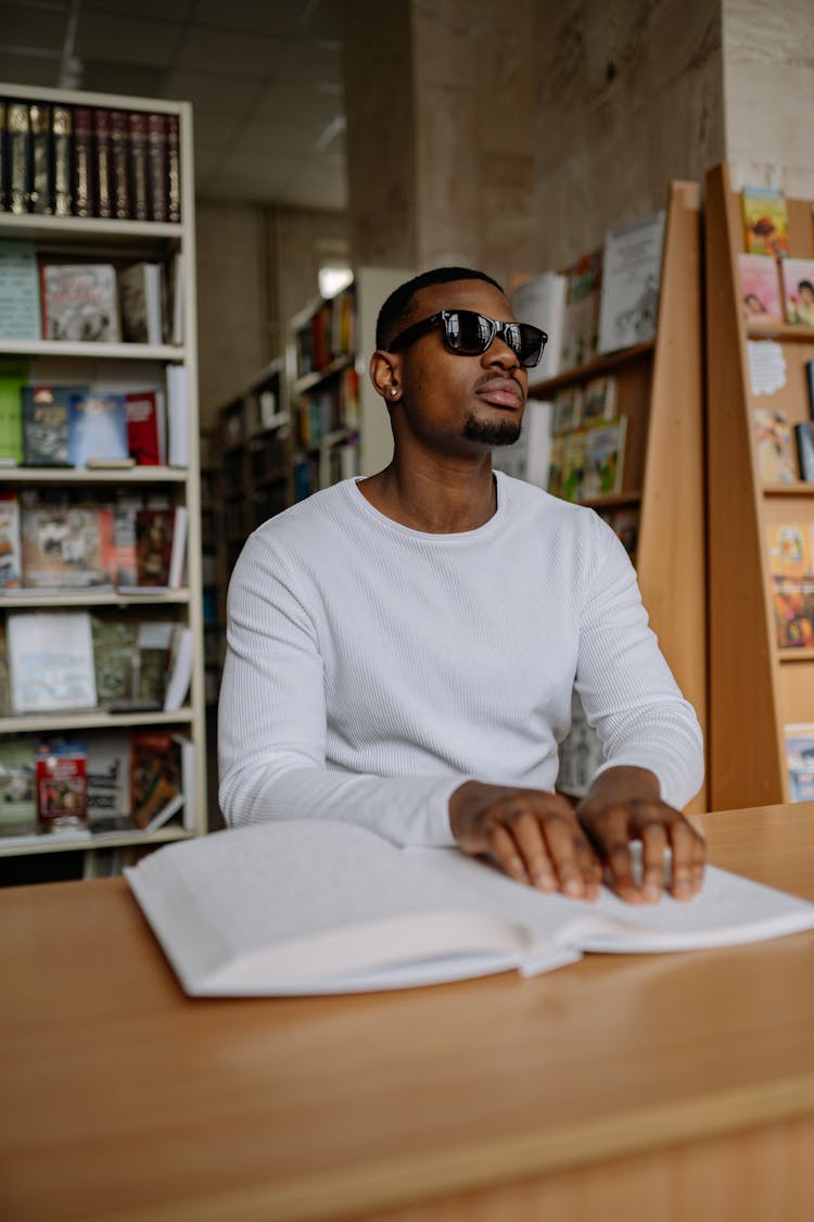 A Man In White Sweater Reading By Braille Method