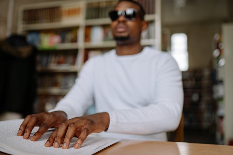 Man In White Sweater Reading By Braille System