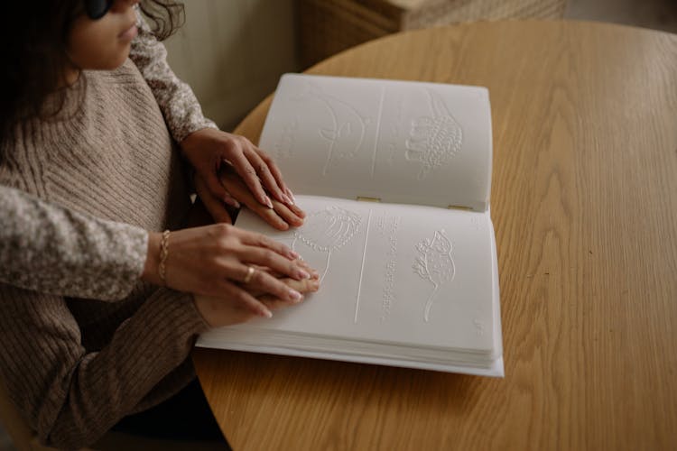 Woman Helping Girl In Reading Braille Alphabet