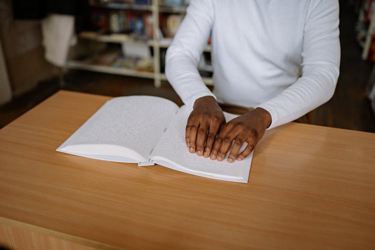 Person In White Sweater Reading By Braille