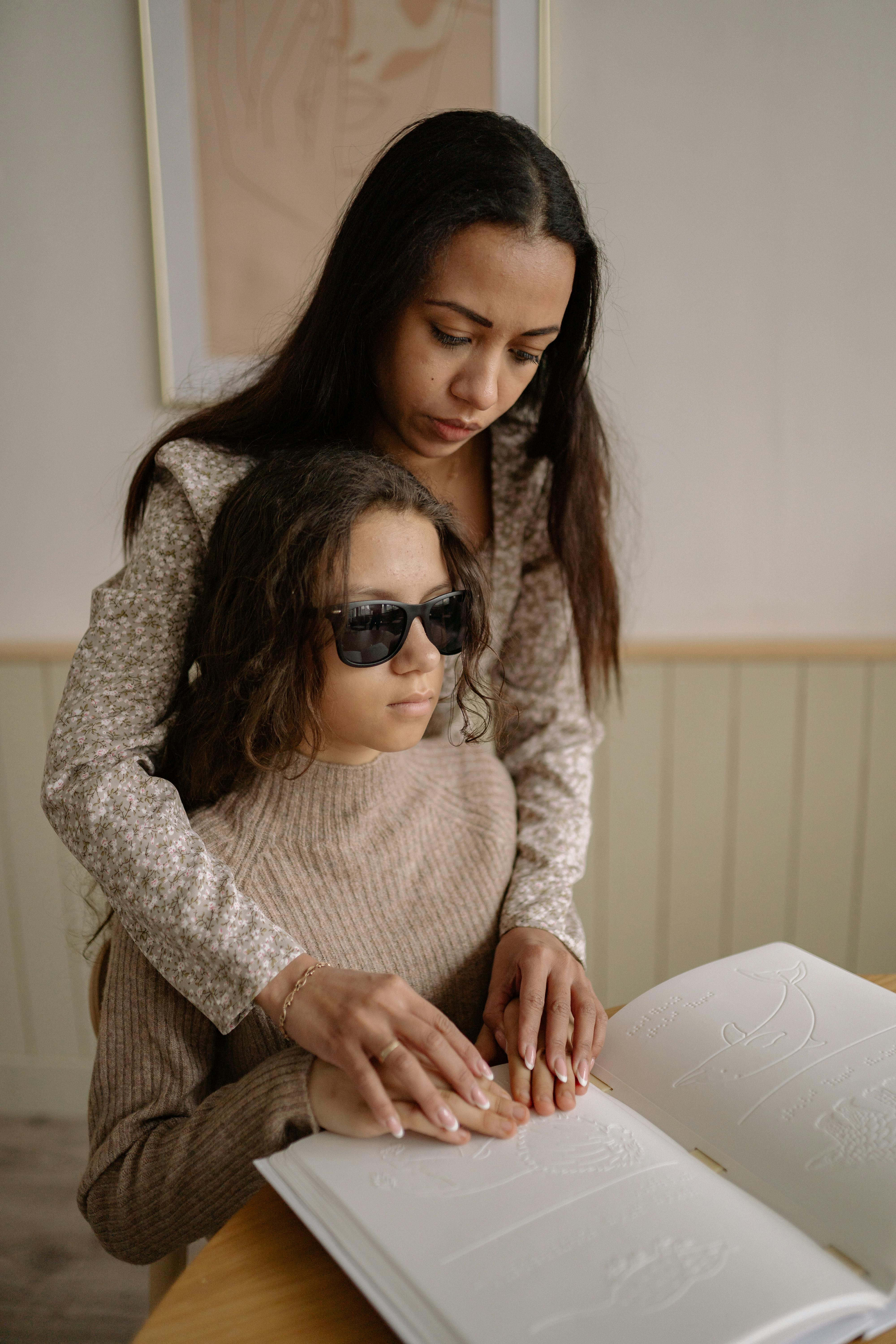 women by table with book in braille