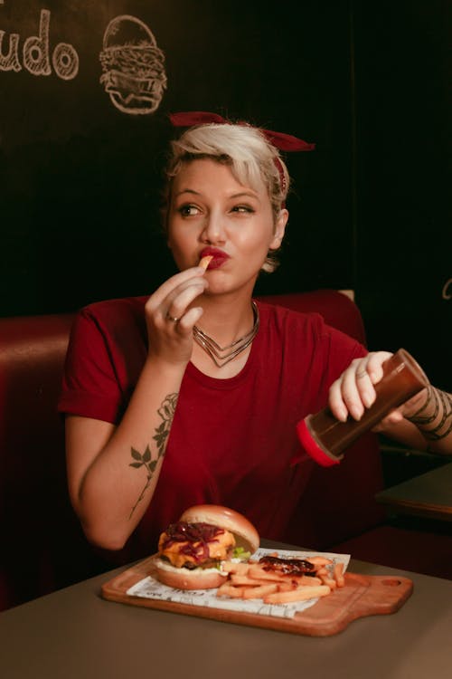 Woman Sitting and Eating Fast Food