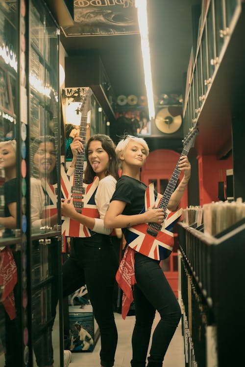 Women Posing While Carrying Electric Guitar