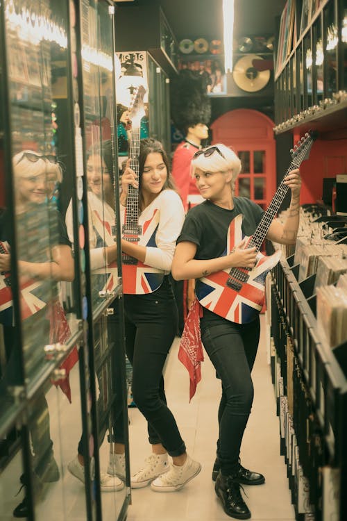 Free Women in the Store Holding Guitars Stock Photo