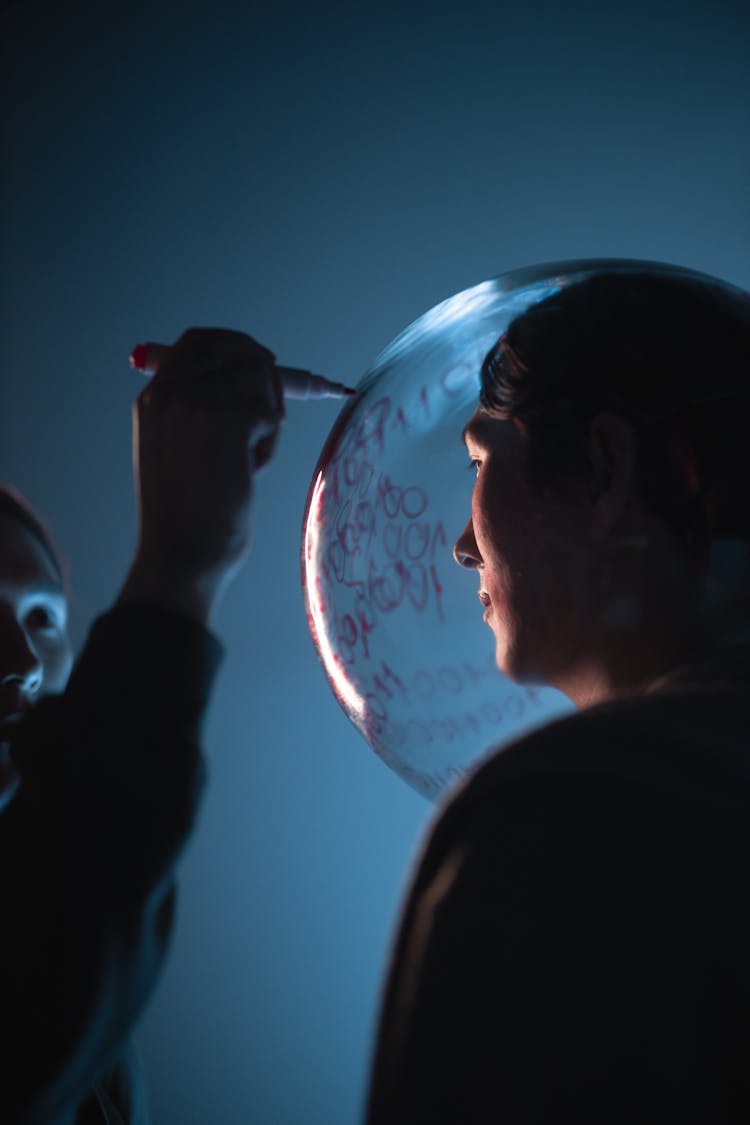 Man Writing On Glass Sphere On Head