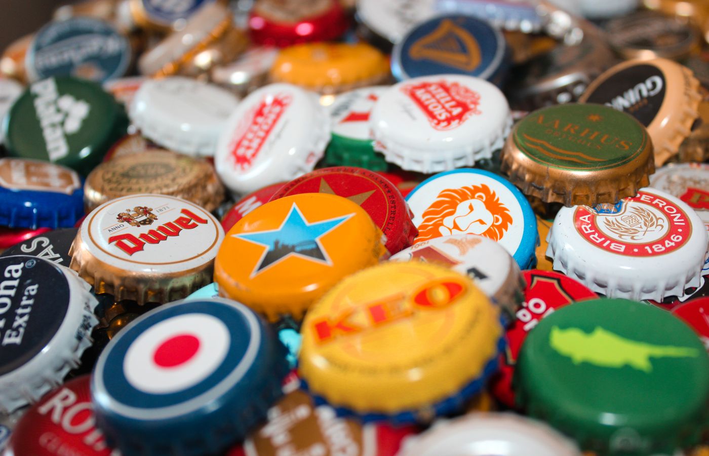 A vibrant assortment of beer bottle caps showcasing various brands and colors.