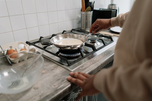 Person Holding Stainless Steel Cooking Pan