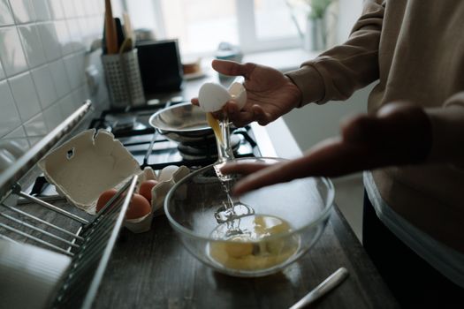 Hands delicately cracking eggs over a bowl, perfect for cooking and kitchen-themed projects.