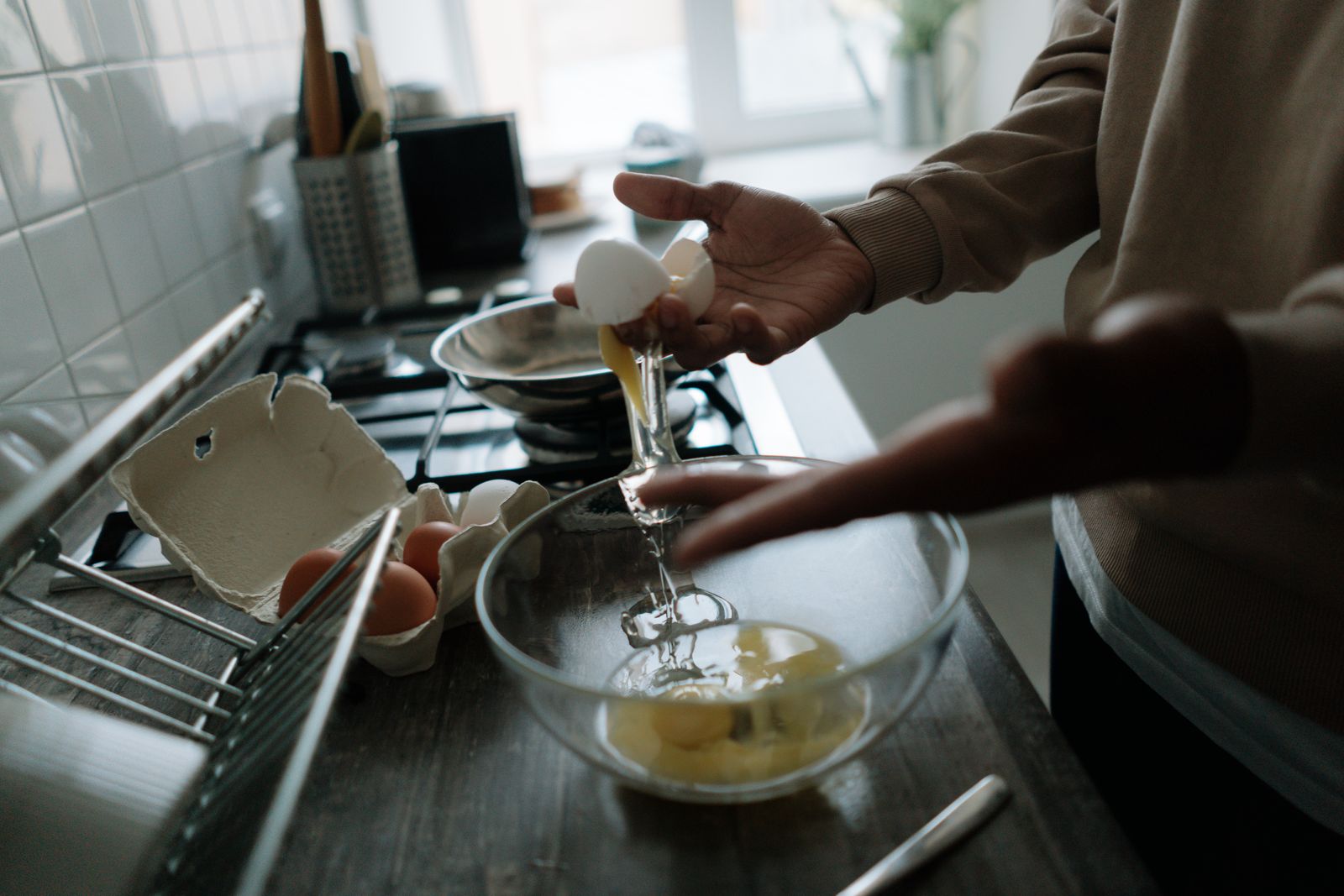 Hands delicately cracking eggs over a bowl, perfect for cooking and kitchen-themed projects.