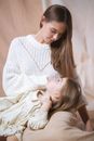 Woman in White Knit Sweater Carrying Baby