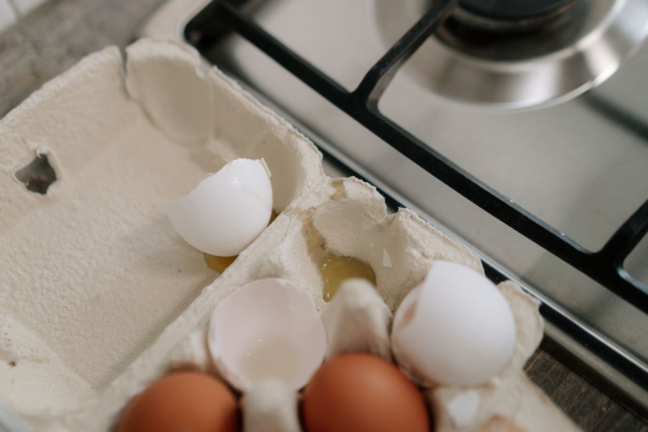 Eggs in carton on kitchen counter near stovetop