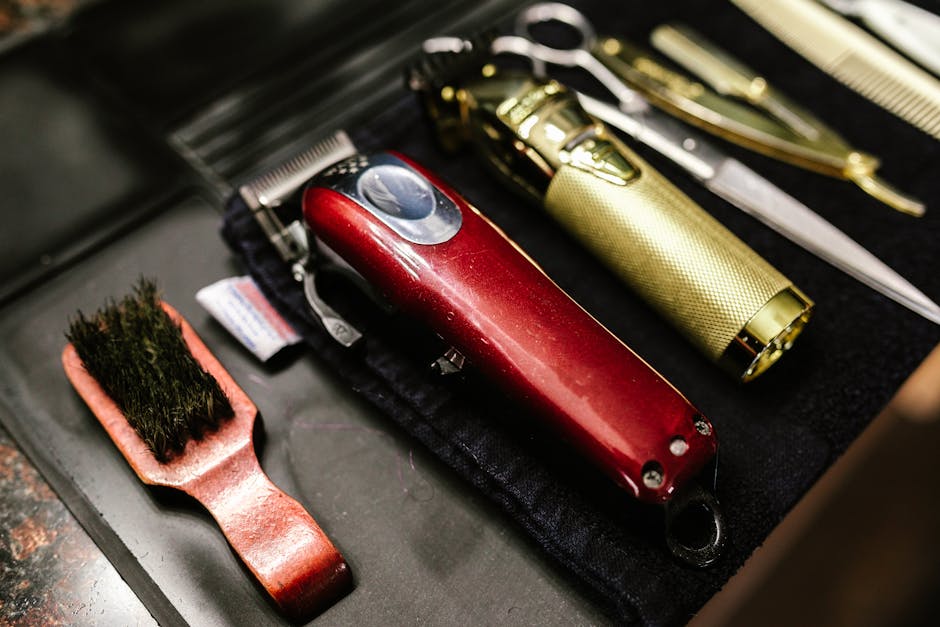Close-up of professional barber tools including clippers and scissors arranged neatly for a haircut.