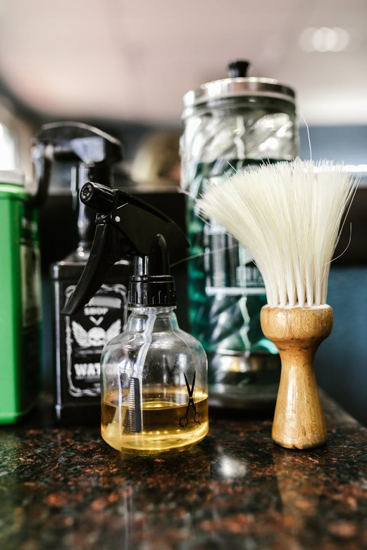 Close Up Of A Spray Bottle Beside A Barber's Brush