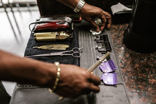 High-angle shot of barber tools on a work mat, including scissors and clippers.