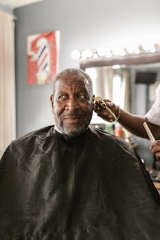 African American man receiving a trim in a barbershop with stylist in action.