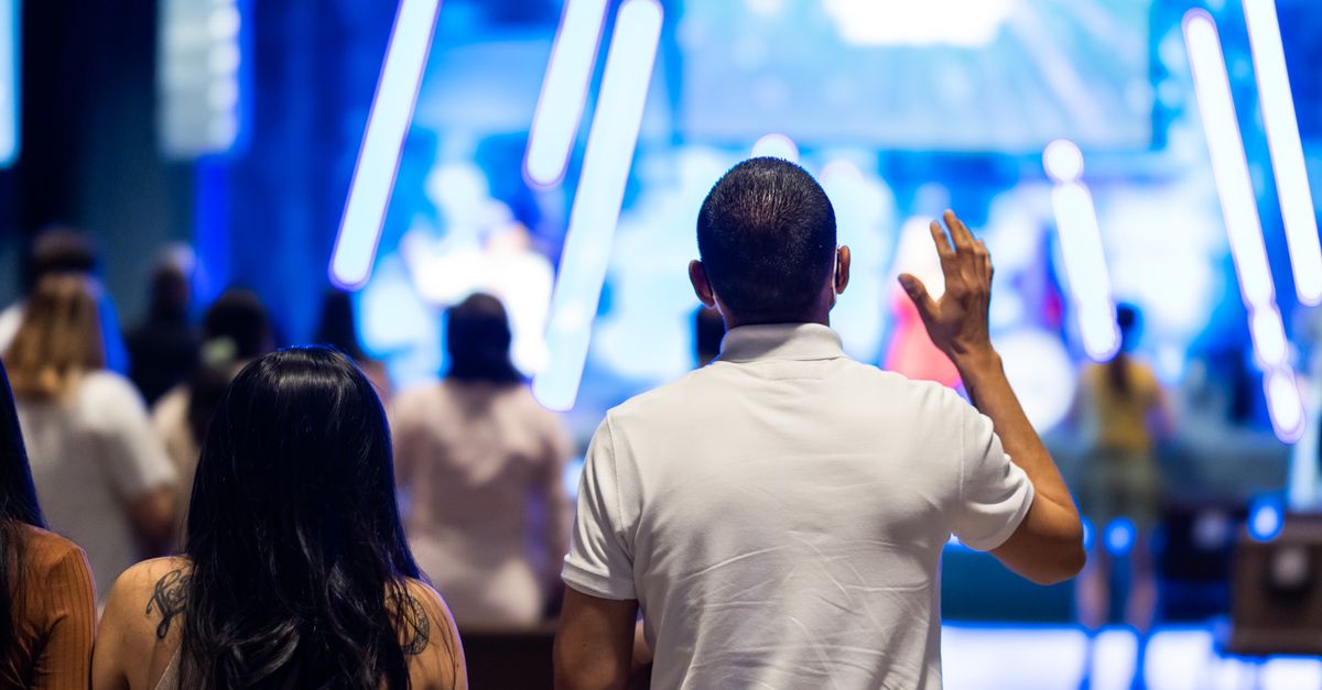 Inside view of Christ Embassy Loveworld Arena congregation during a worship service, with modern lighting and sound systems