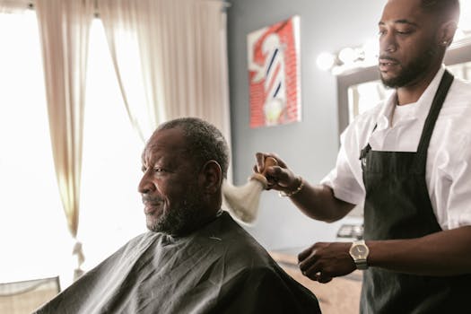 A skilled barber giving a haircut to a senior man in a contemporary barbershop setting.