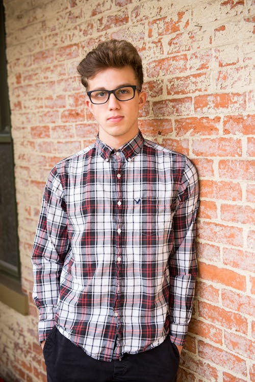Man In Red And White Plaid Dress Shirt And Black Bottoms With Black Frame Eyeglasses