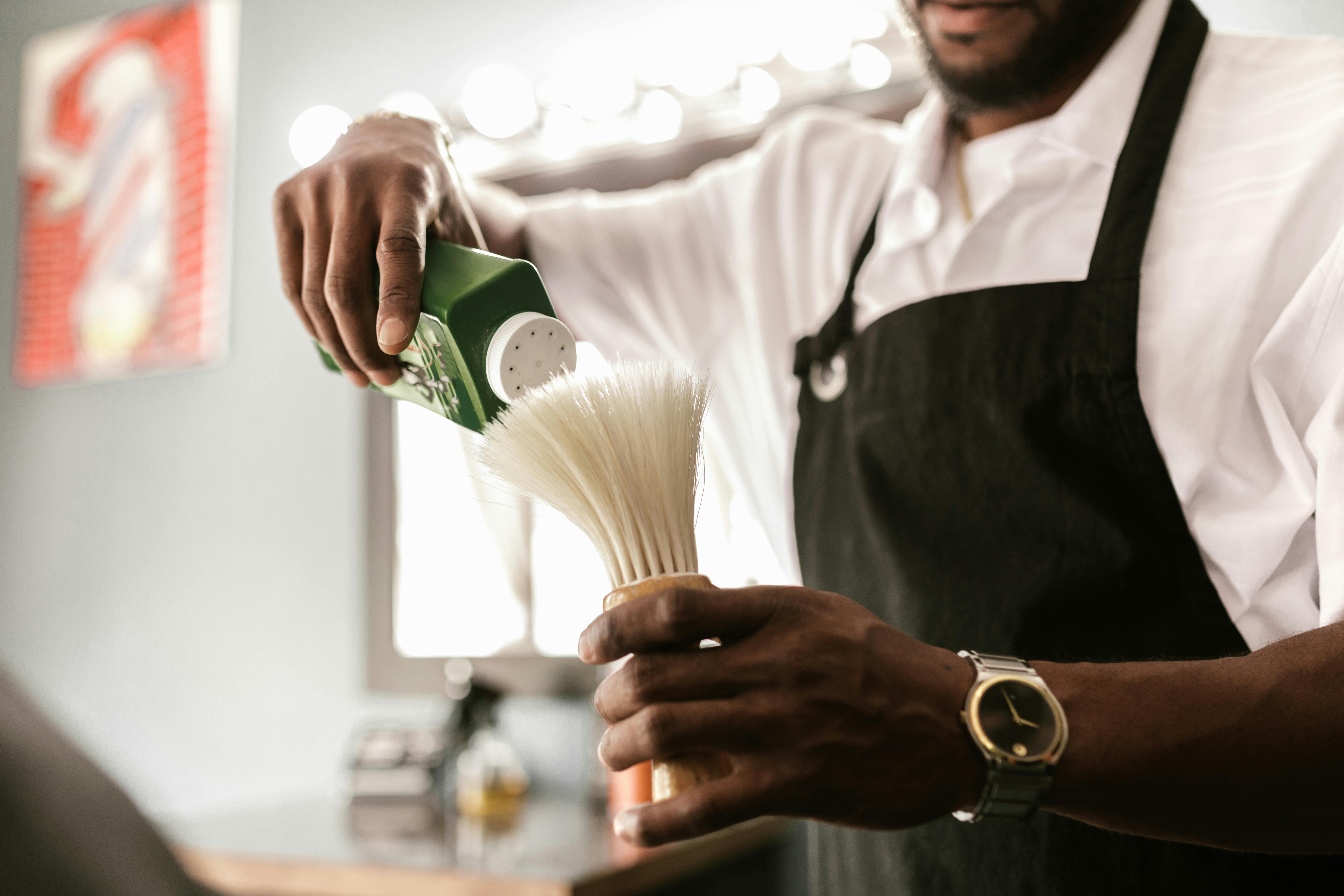 a barber putting powder on a barber duster