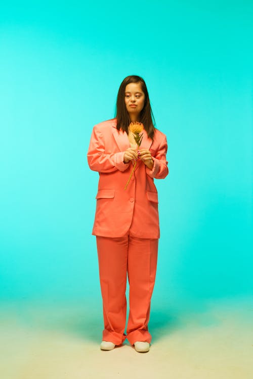 A Woman Posing while Holding a Flower