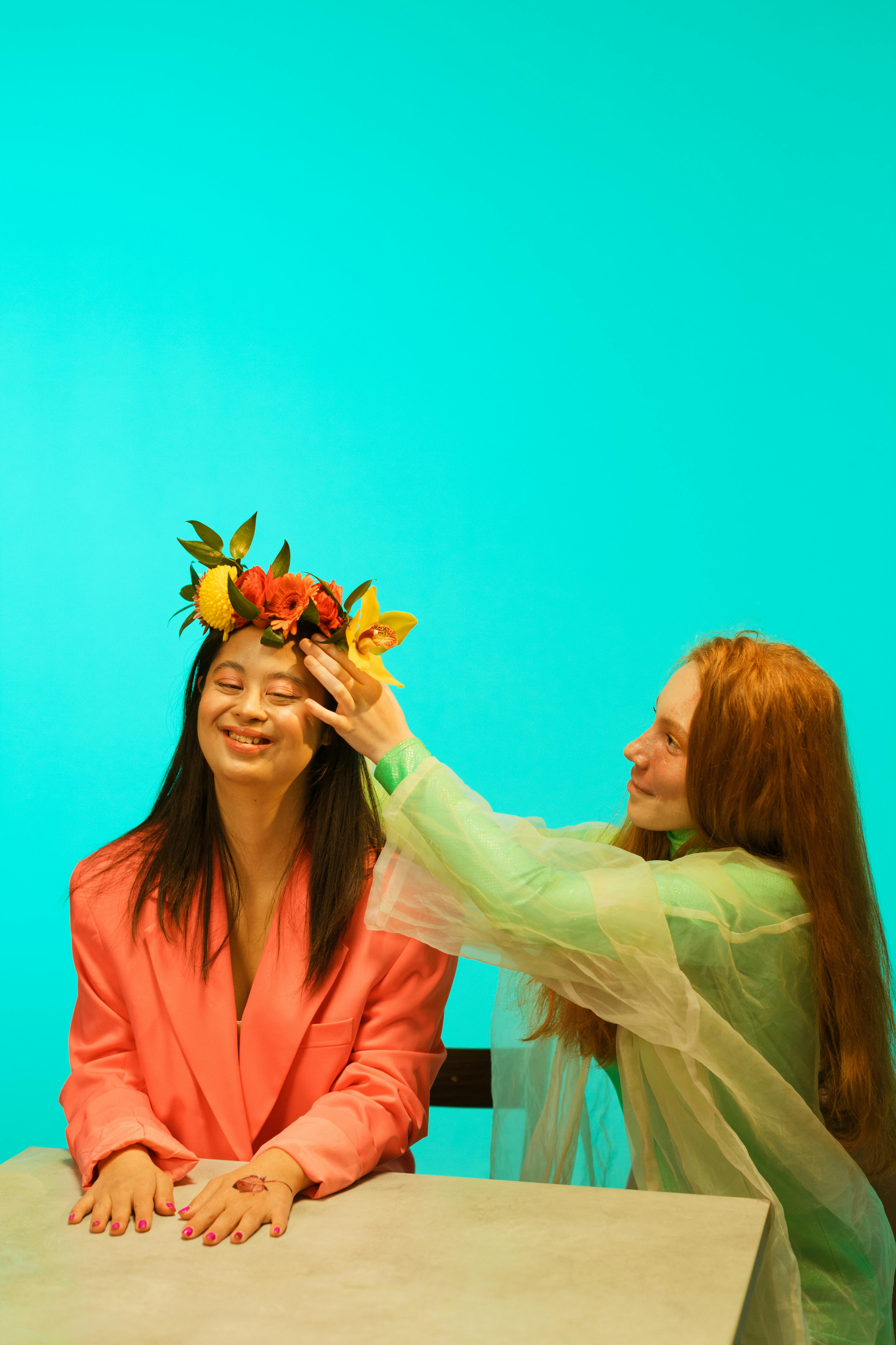 a person placing a flower crown on a happy woman