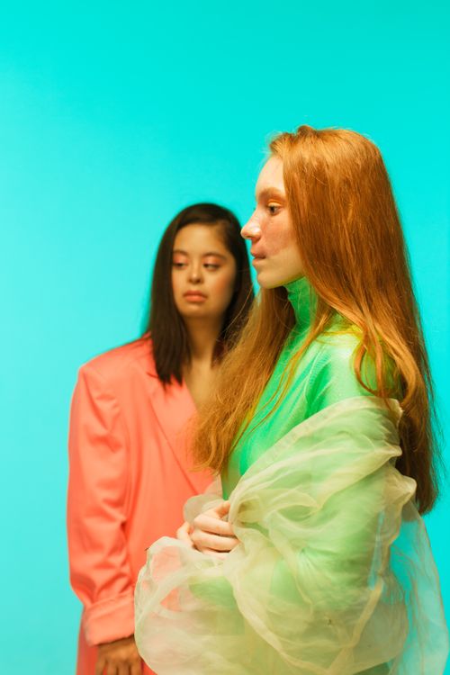 Free Artistic portrait capturing two women in colorful attire against a teal background, highlighting fashion and diversity. Stock Photo