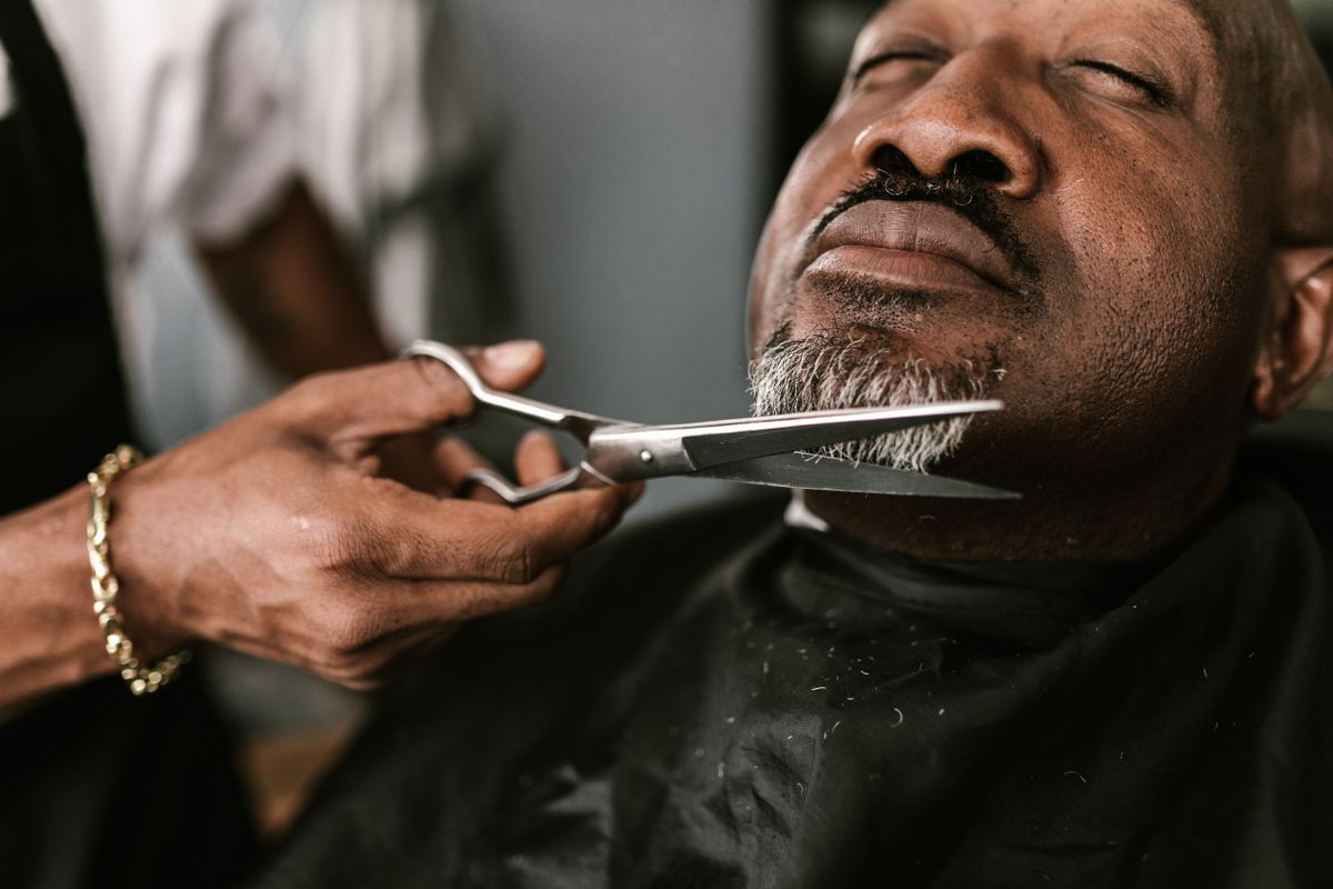 Black client receiving barber grooming in a barbershop