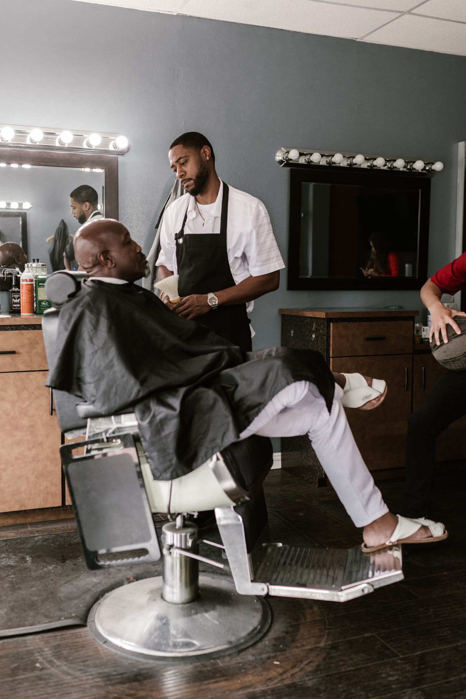 Professional barber carefully grooming an African man's beard