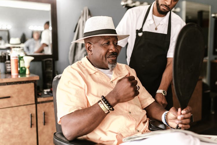 A Man Looking At A Mirror While Sitting In A Barber Chair