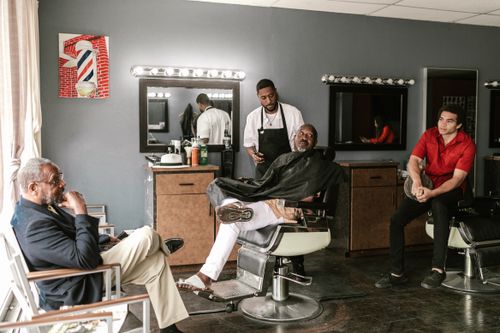 Barber and clients in a bright barbershop