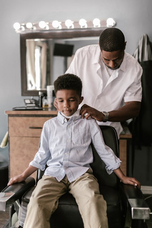 Free Boy Sitting on the Chair Getting His Haircut Stock Photo