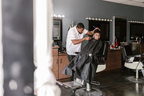 Barber Serving Little Black Boy in Barbershop