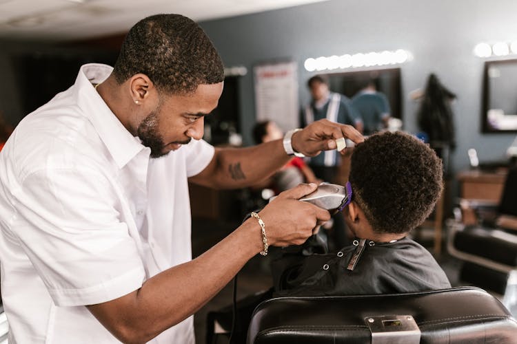 Man In White Dress Shirt Shaving Boy's Hair