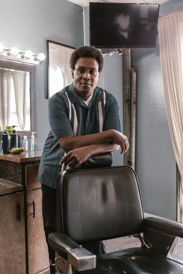 A Man Standing By A Barber Chair