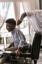 Boy in Blue Long Sleeves Shirt Sitting on Barber Chair