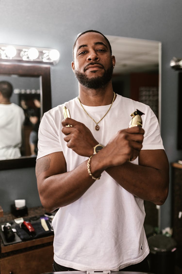 A Barber Holding A Straight Razor And A Hair Clipper