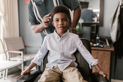 A Boy Sitting at a Barber