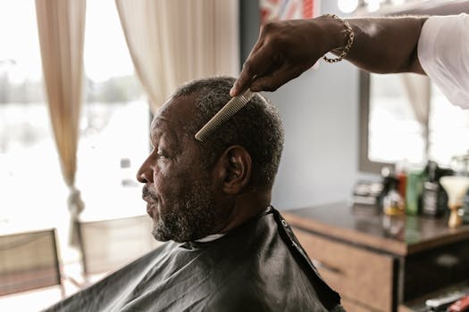 A senior man receiving a haircut at a barbershop, showcasing grooming in a classic setting.