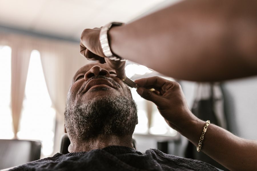 Barber shaving a client with precision