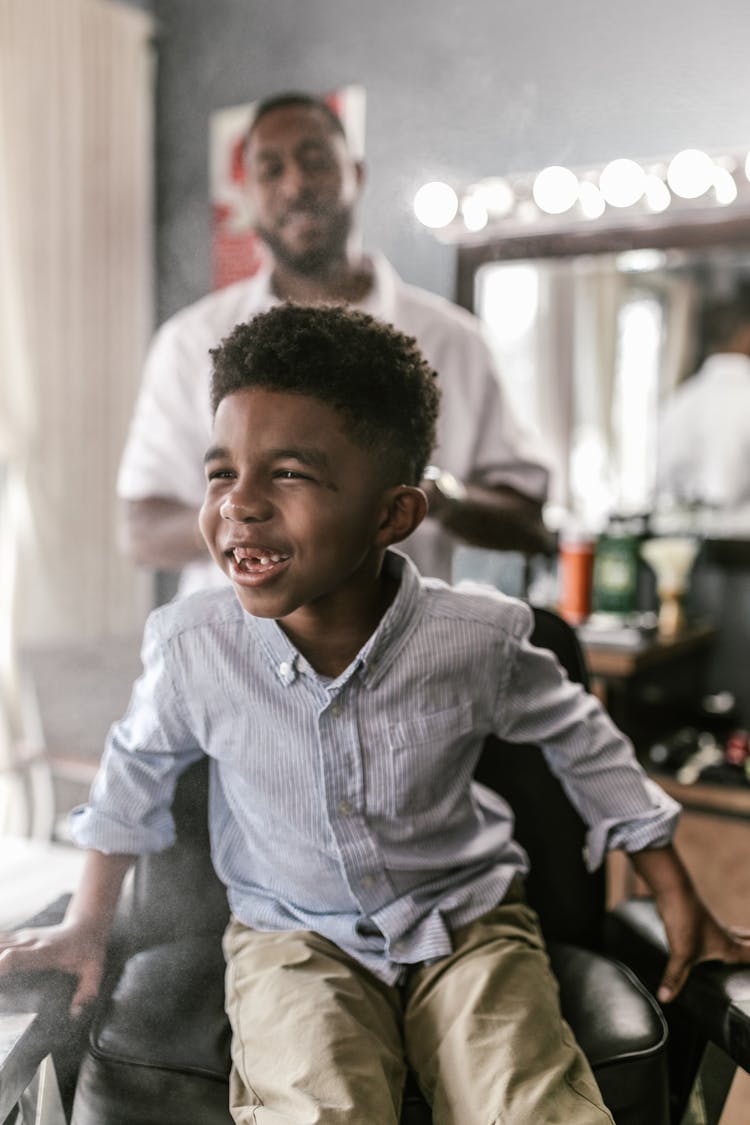 A Boy Sitting On A Barber Shop Chair