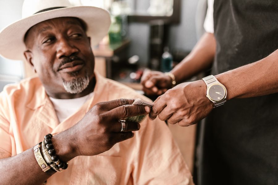 Pelanggan barbershop membayar kepada kapster