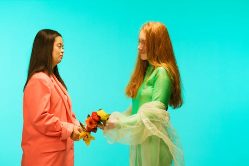 Women Facing Each Other Holding flowers