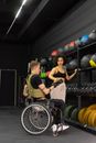 A Personal Trainer Handing a Dumbbell to her Client