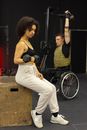 Woman in Black Sports Bra and White Pants Riding on Black Wheelchair