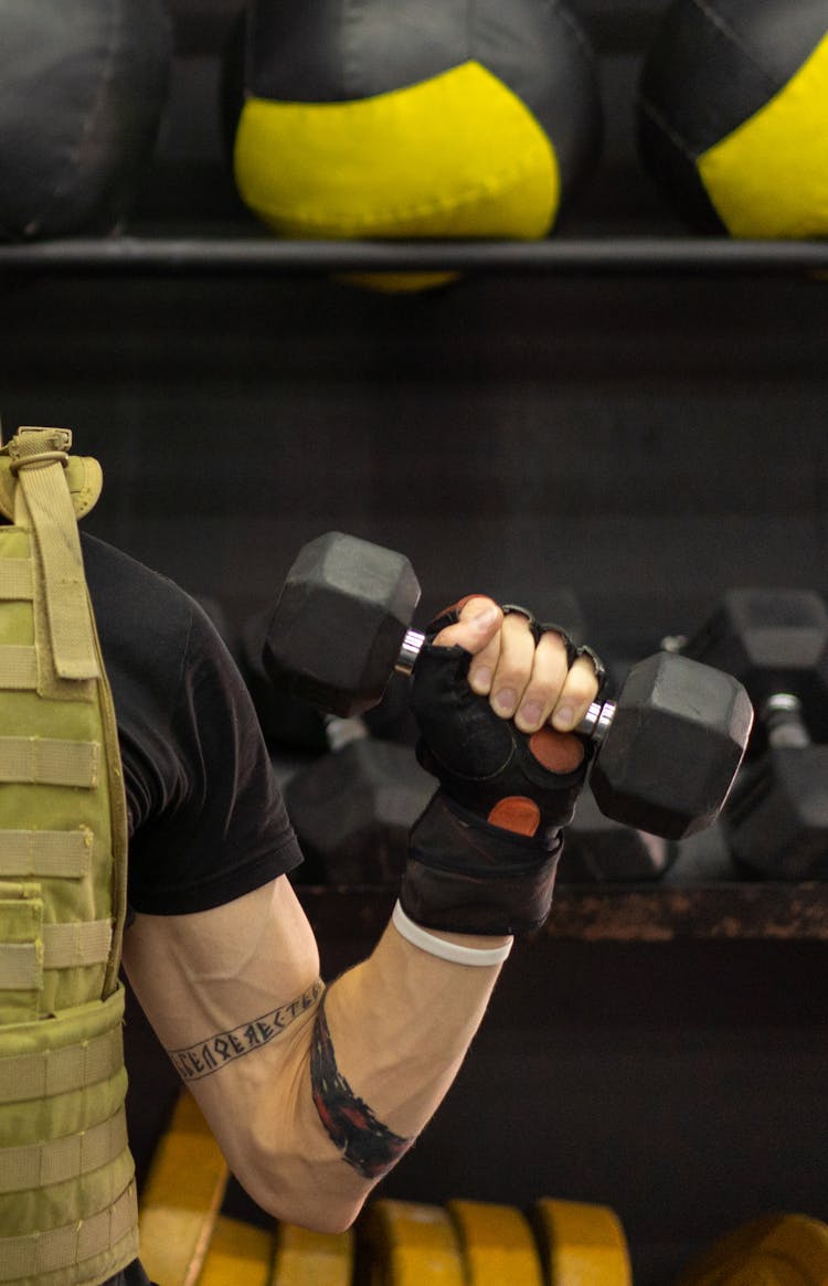 A Person In A Weighted Vest Holding A Dumbbell